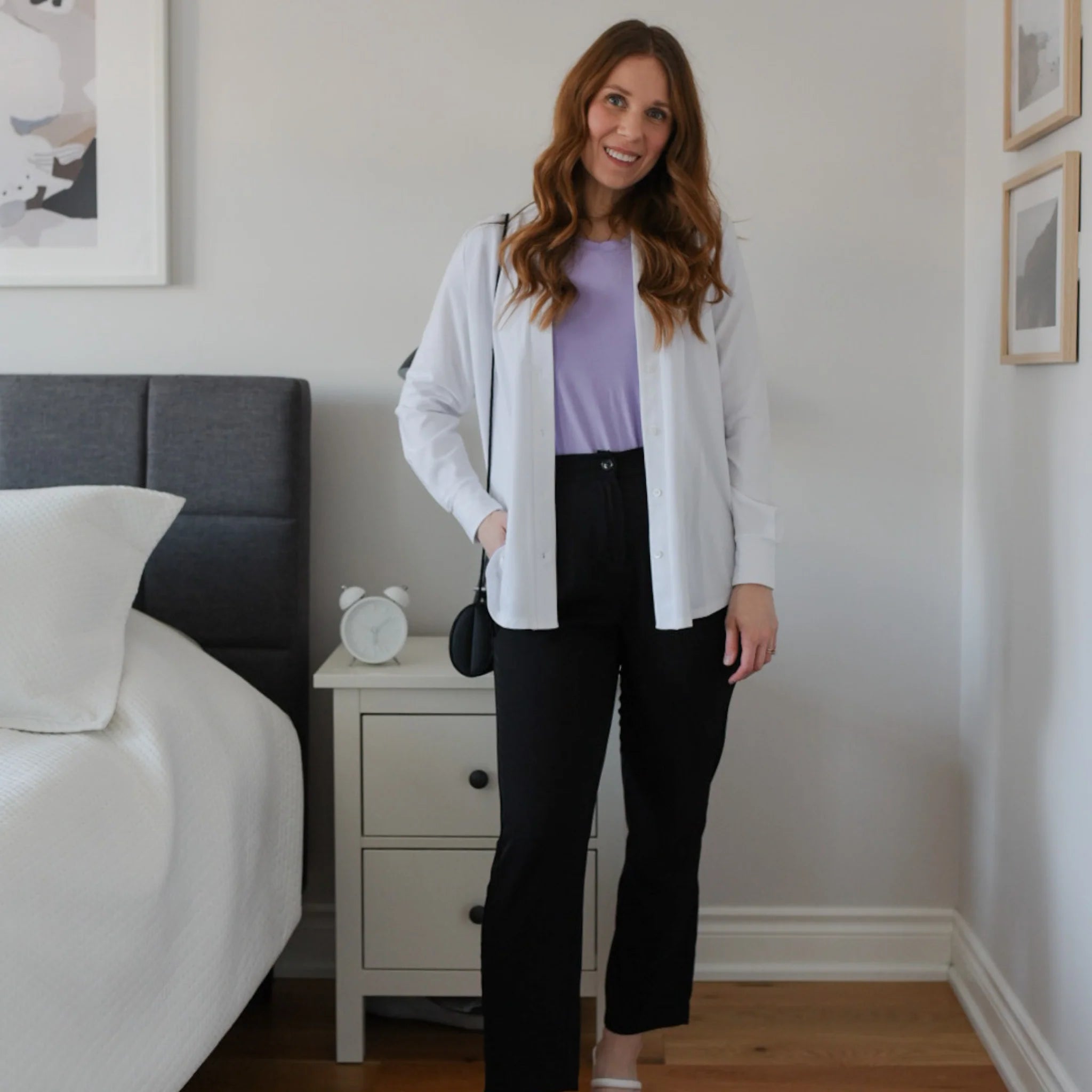 Woman wearing white long sleeve button up shirt with purple shirt and black tapered sweatpants