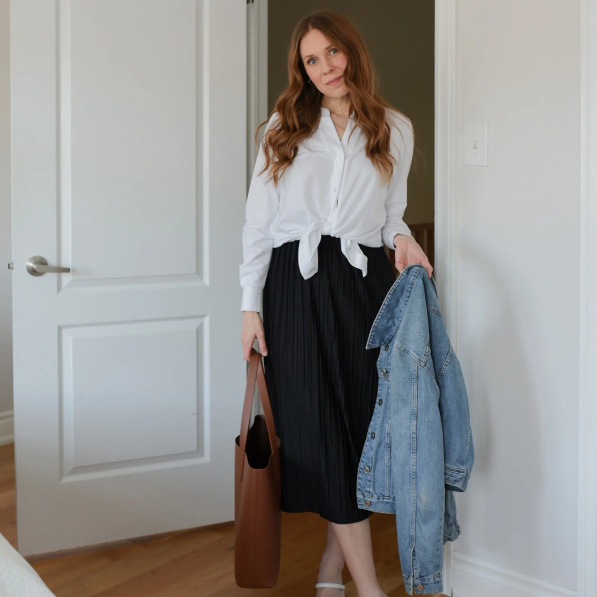 Woman wearing white long sleeve button up shirt with black flowing skirt