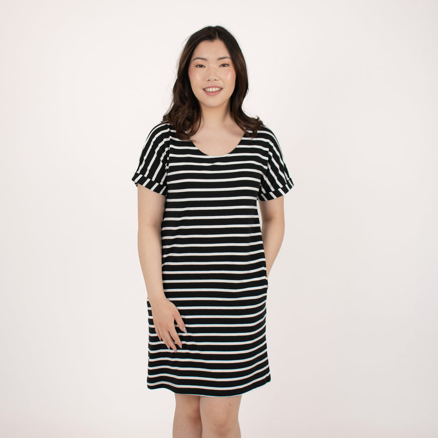 Woman wearing loose horizontal black and white striped short sleeve knee length dress with pockets