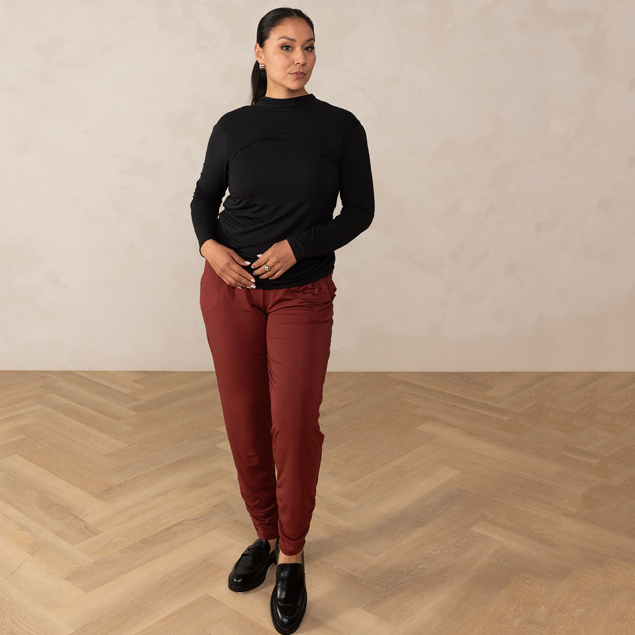 Woman wearing long sleeve black top with red relaxed pants
