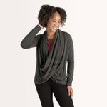 Woman wearing long sleeve dark grey cardigan with red scoop neckline shirt and black fitted pants