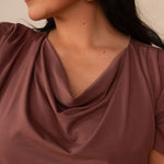 woman wearing a deep mauve cowl neck top