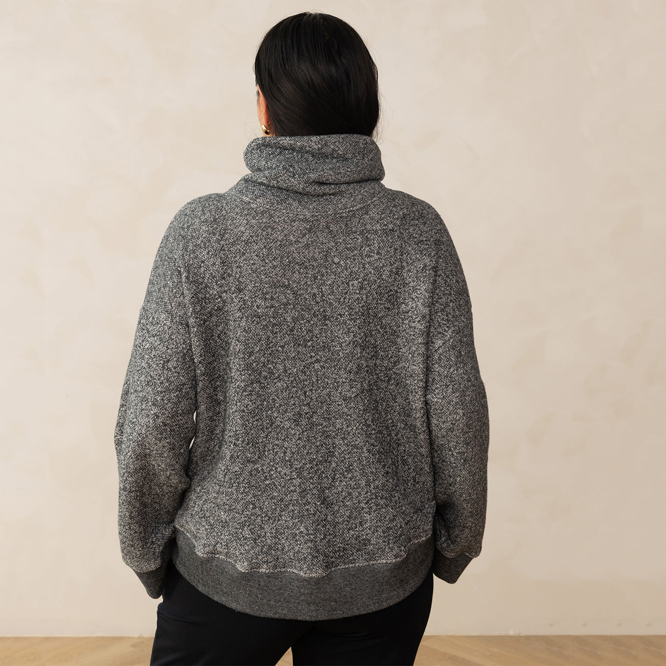 back of a woman wearing a grey heathered high neck sweater