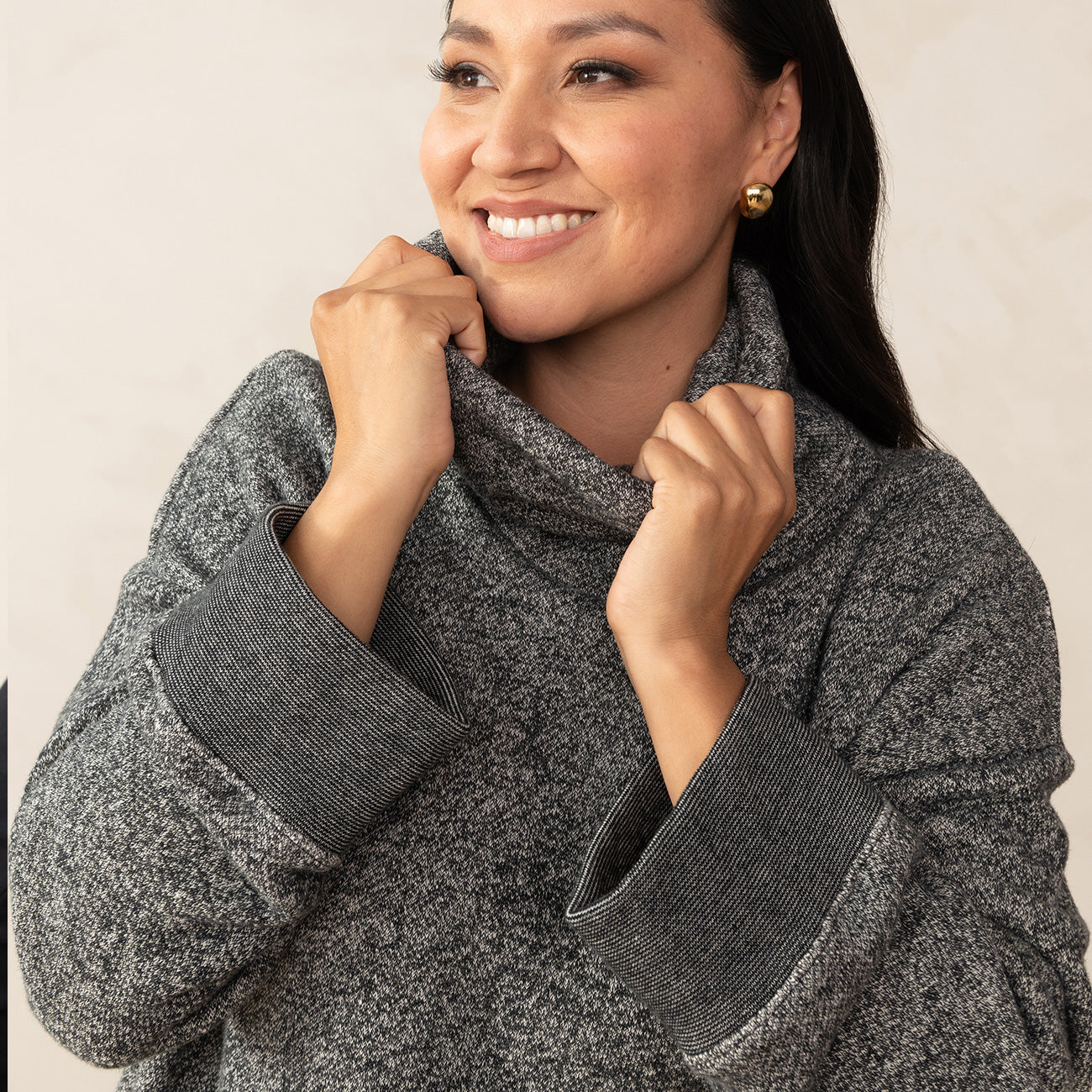 woman holding the neck of a grey sweater