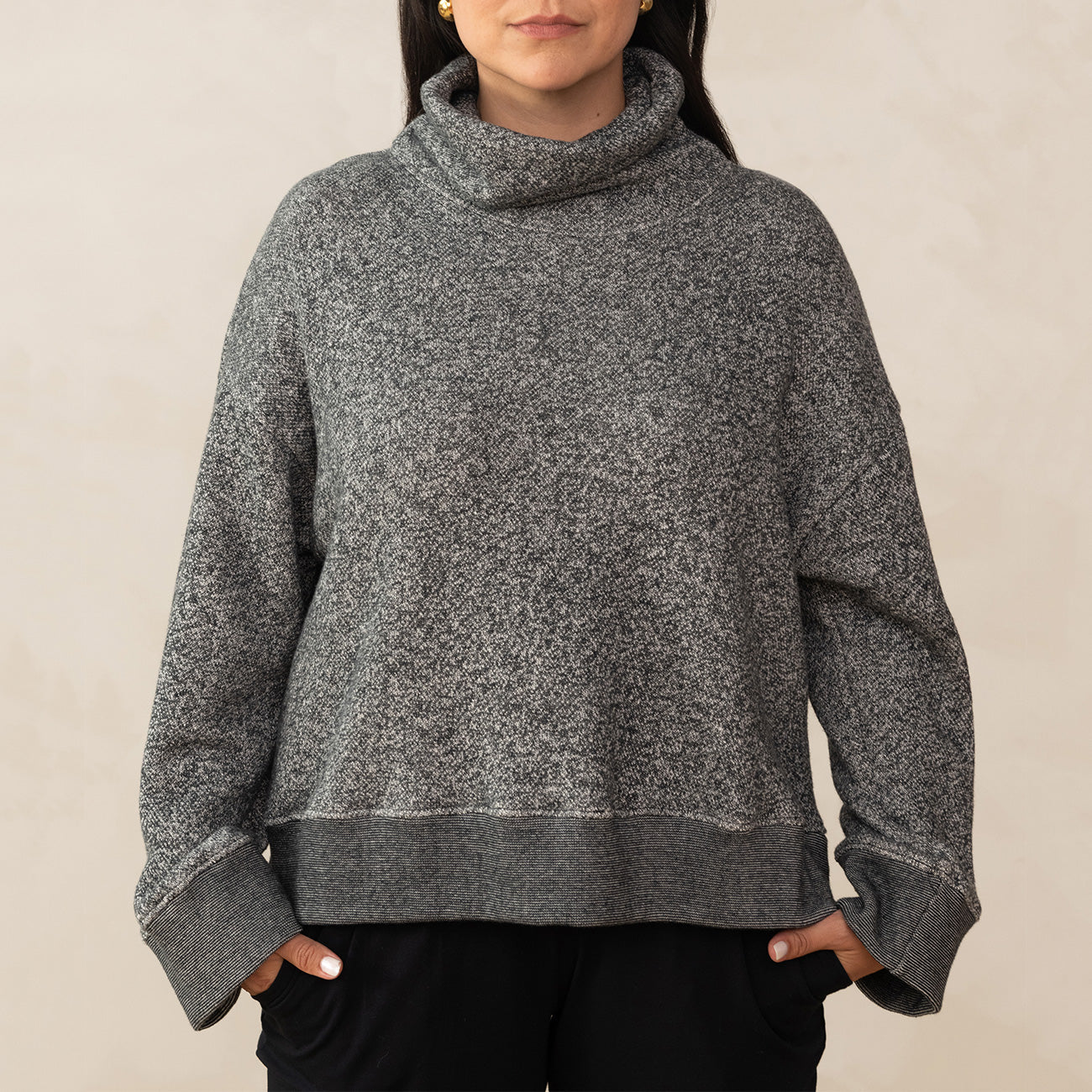 woman wearing a high neck, loose grey sweater