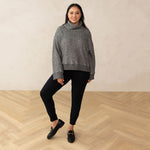 woman wearing a high neck relaxed sweater paired with a black sweatpant and black loafers