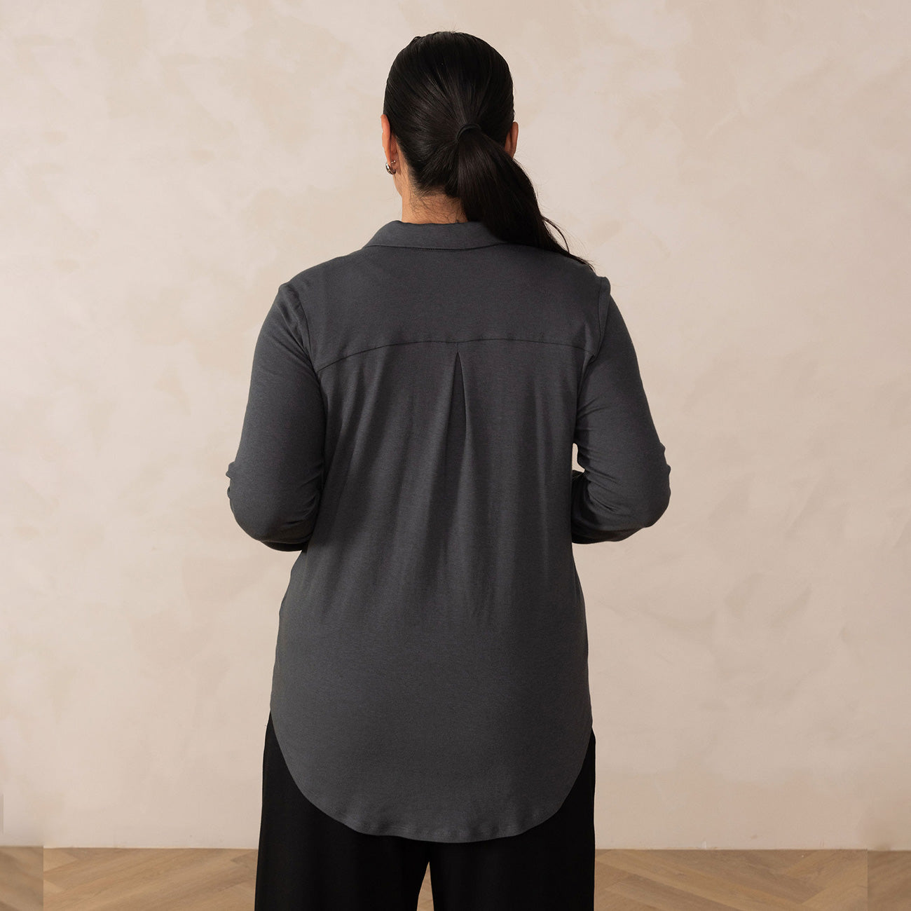 back of a woman wearing a dark grey button up 