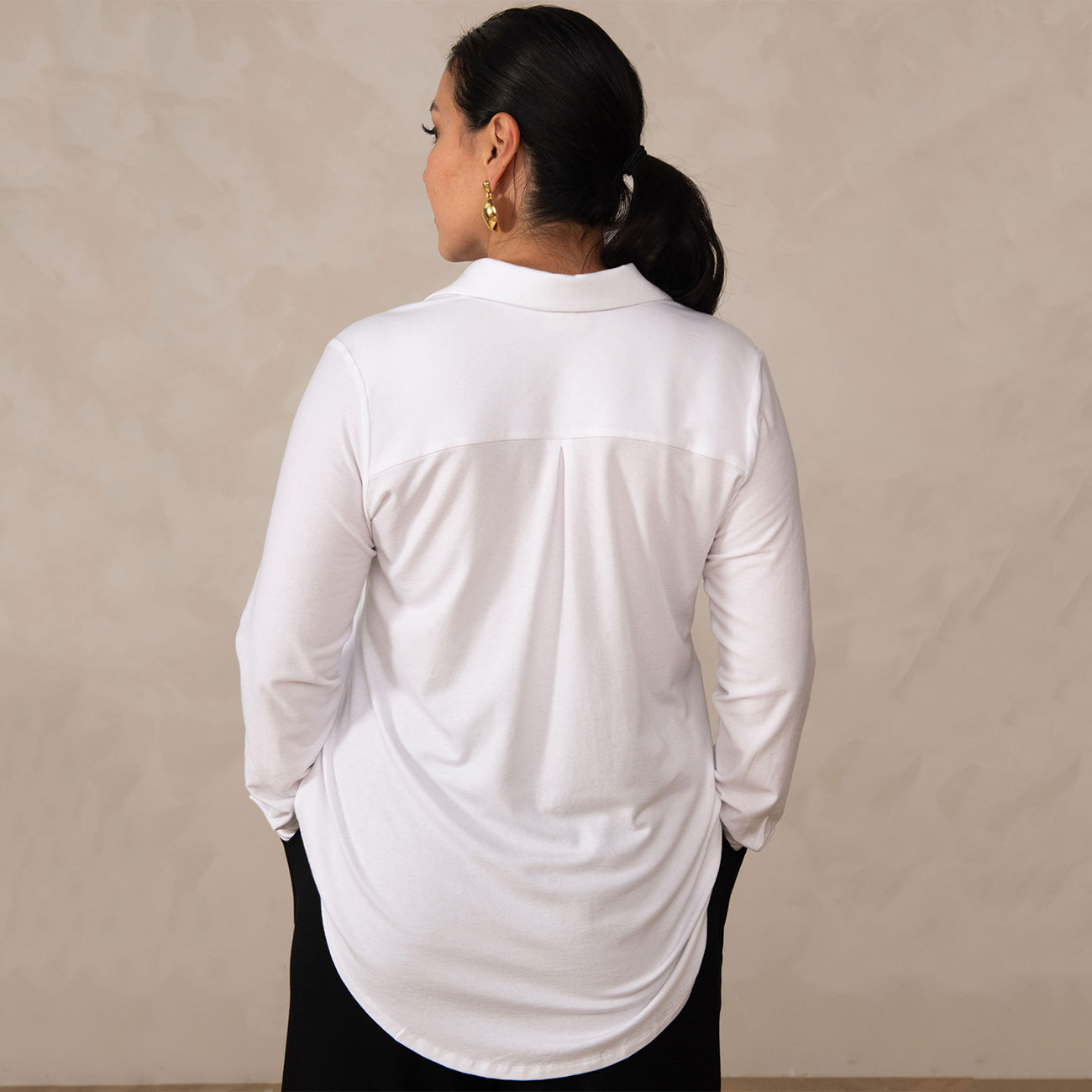 back of a woman wearing a white button-up shirt