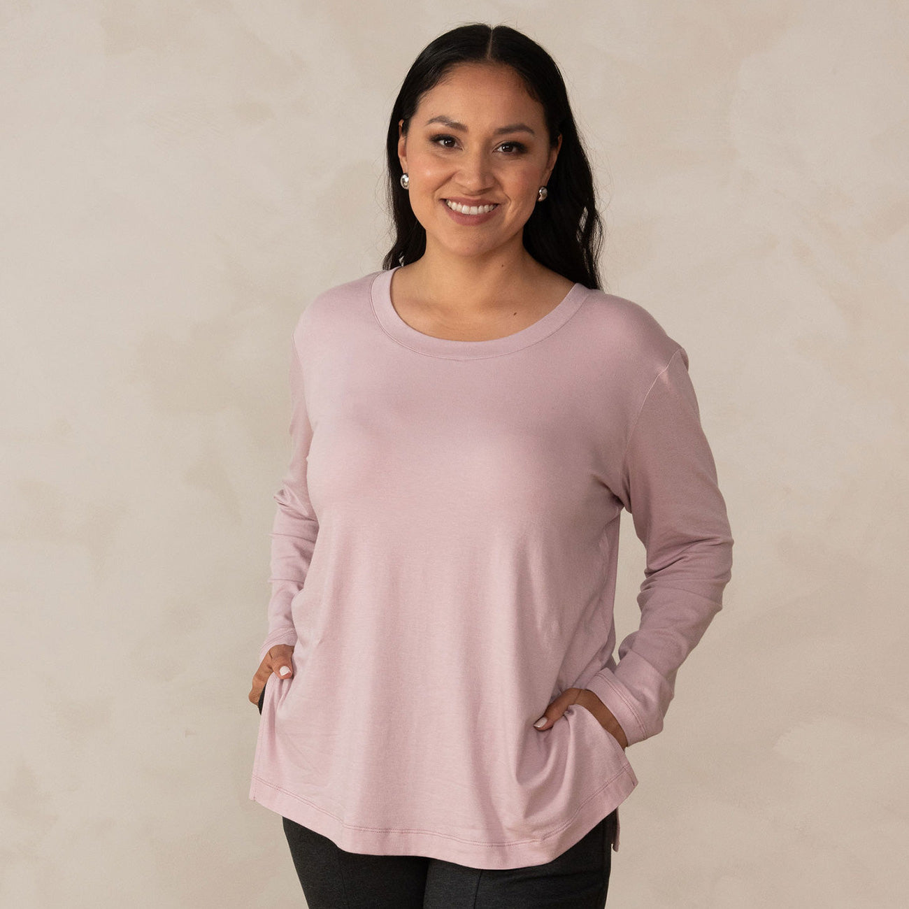 woman wearing a long sleeve scoop neck light pink top