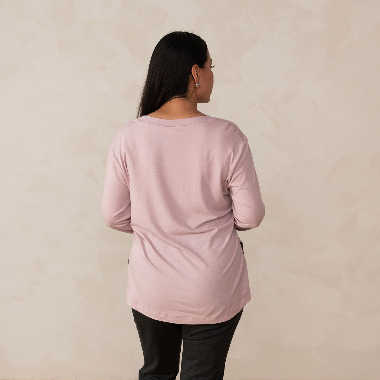 back of a woman wearing a long sleeve scoop neck light pink top