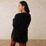 back of a woman wearing a long sleeve scoop neck black top