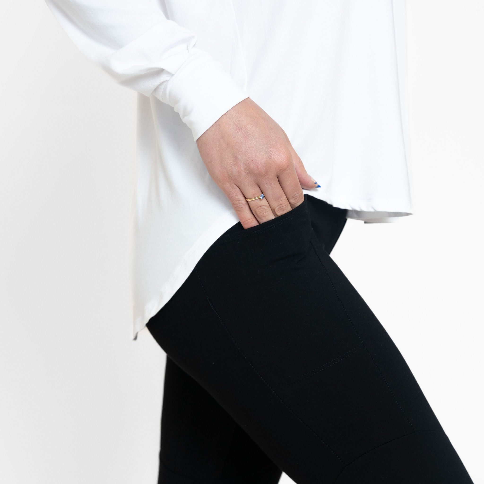 Woman wearing a loose flowing white v-neckline shirt with black leggings