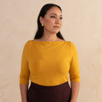 woman wearing a yellow boat neck blouse