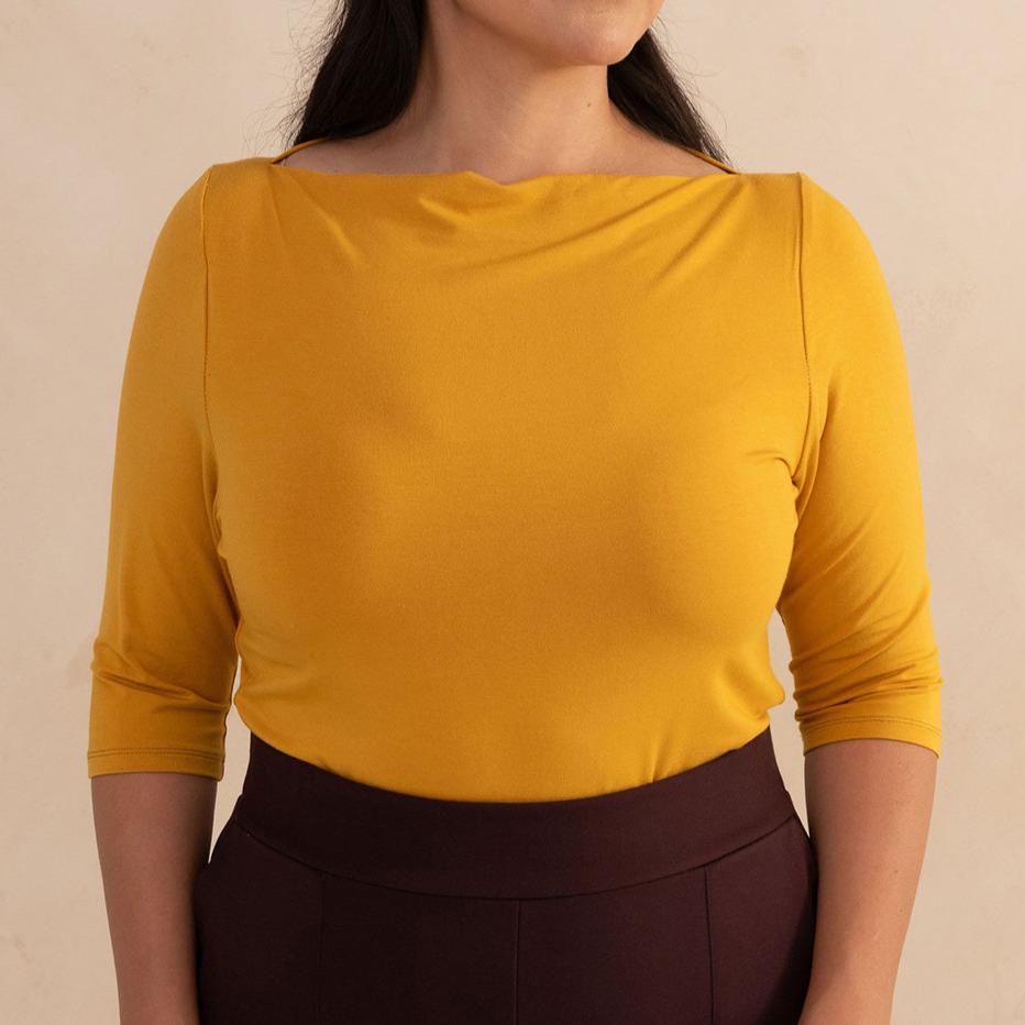 woman wearing a yellow boat neck blouse