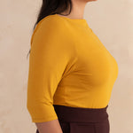 woman wearing a yellow boat neck blouse
