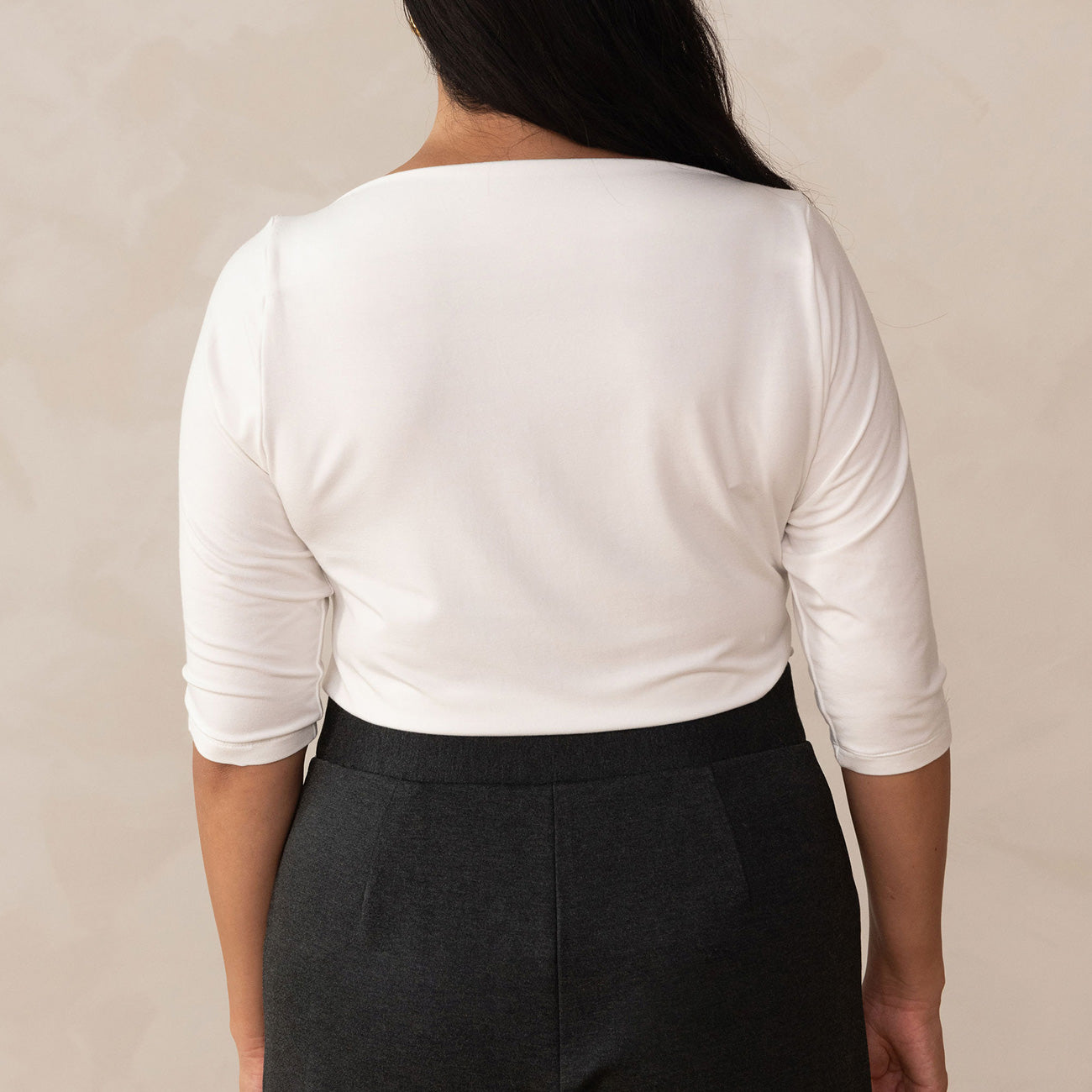 back of woman wearing a white 3/4 sleeve top