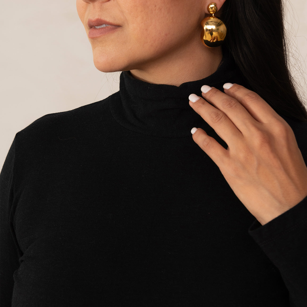 close up image of woman wearing a black turtleneck top
