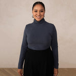 woman wearing a navy turtleneck with black high waisted pants