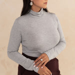 close up image of woman wearing a light grey turtleneck