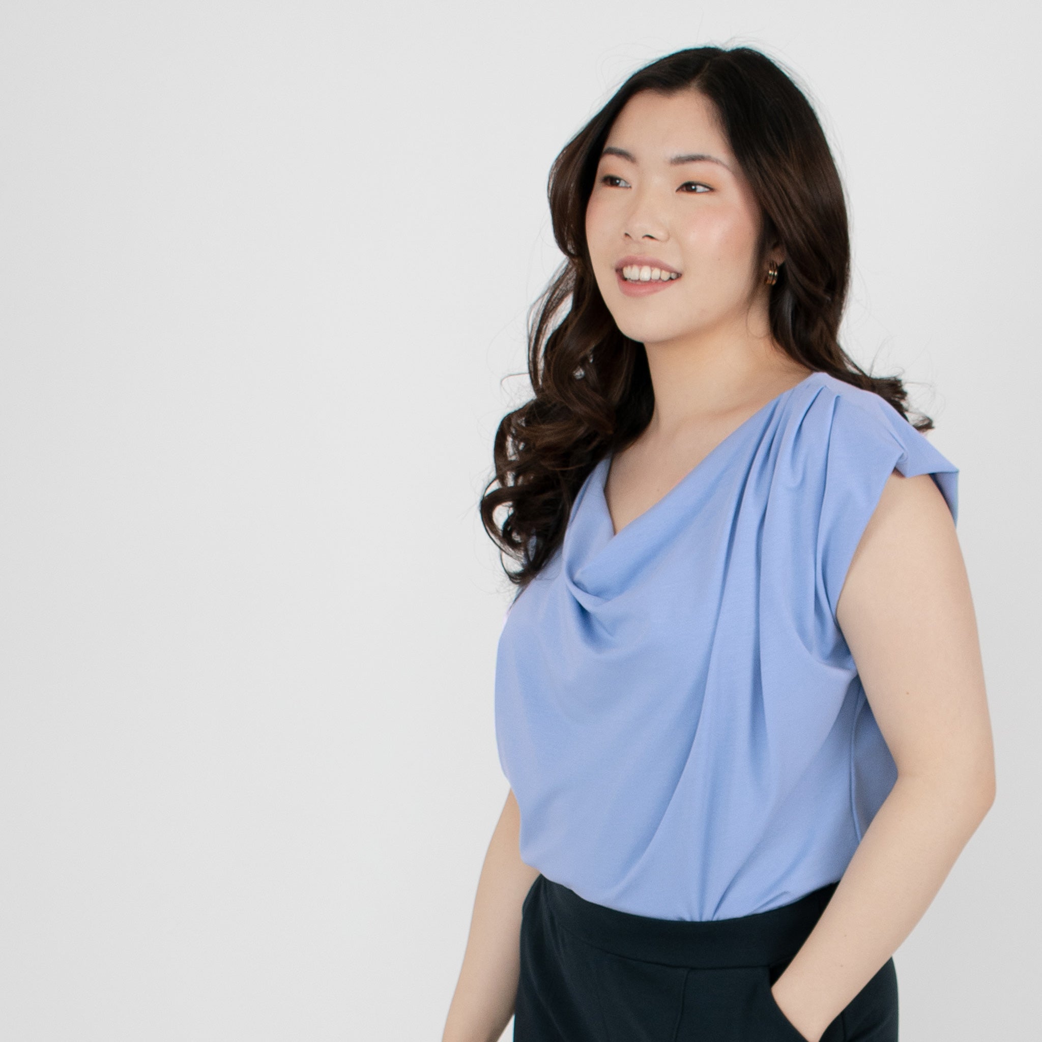Woman wearing loose periwinkle versatile top paired with black fitted pants