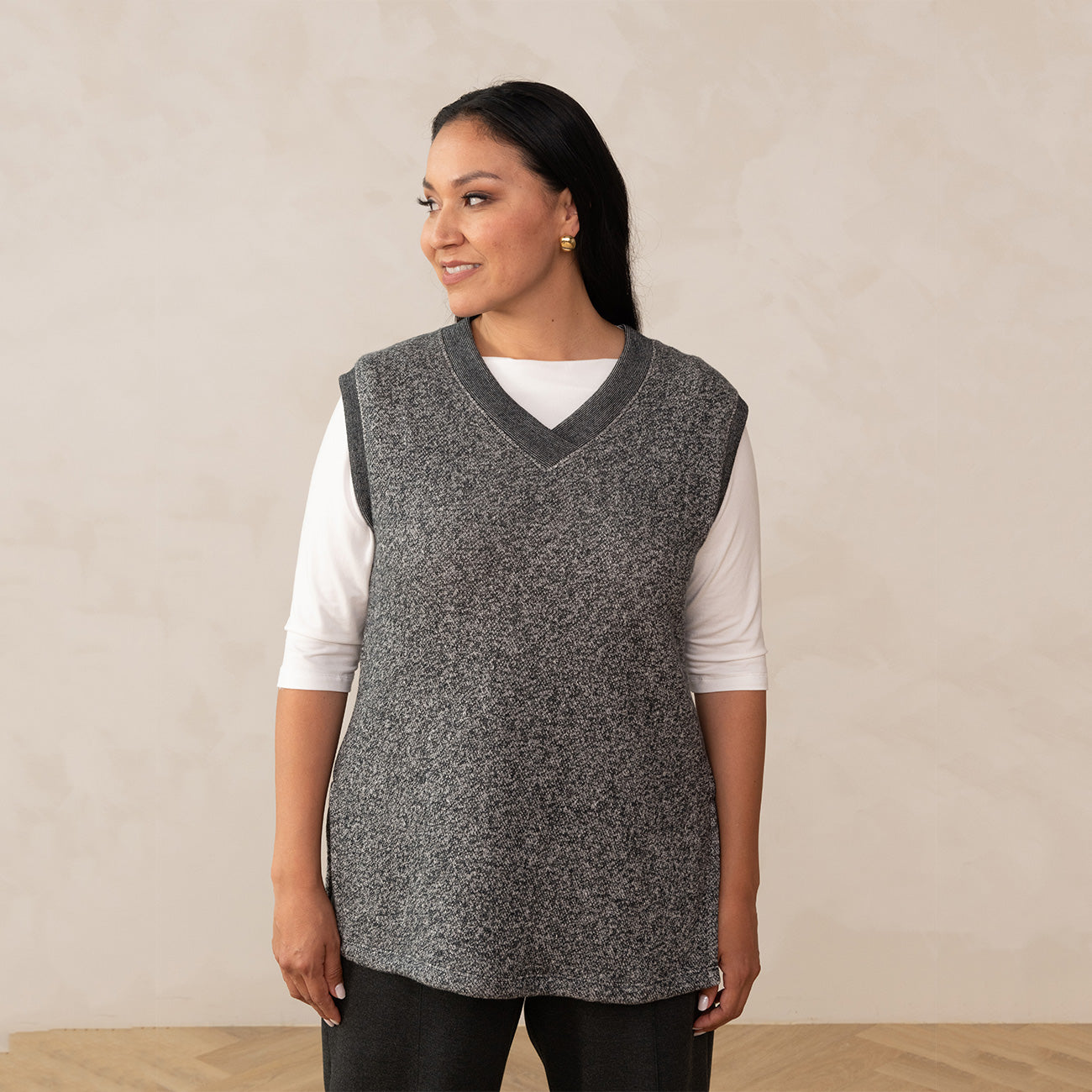 woman wearing a heirloom grey vest and a boat neck white top