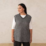 woman wearing a heirloom grey vest and a boat neck white top