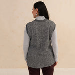 back of a woman wearing a heirloom grey vest and a light grey turtleneck