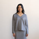 Woman wearing a grey v-neck sweater