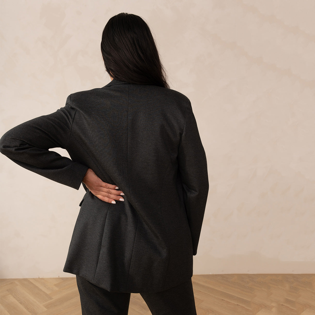 back of a woman wearing a grey blazer