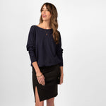 Woman wearing loose navy blue scoop neckline sweatshirt with black skirt