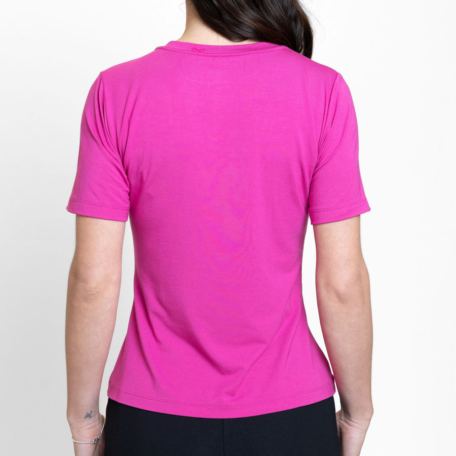Woman wearing loose bright pink crew neck t-shirt with black tailored ankle length pants