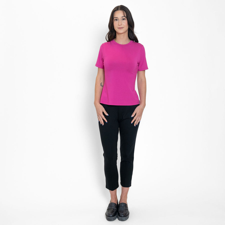 Woman wearing loose bright pink crew neck t-shirt with black tailored ankle length pants