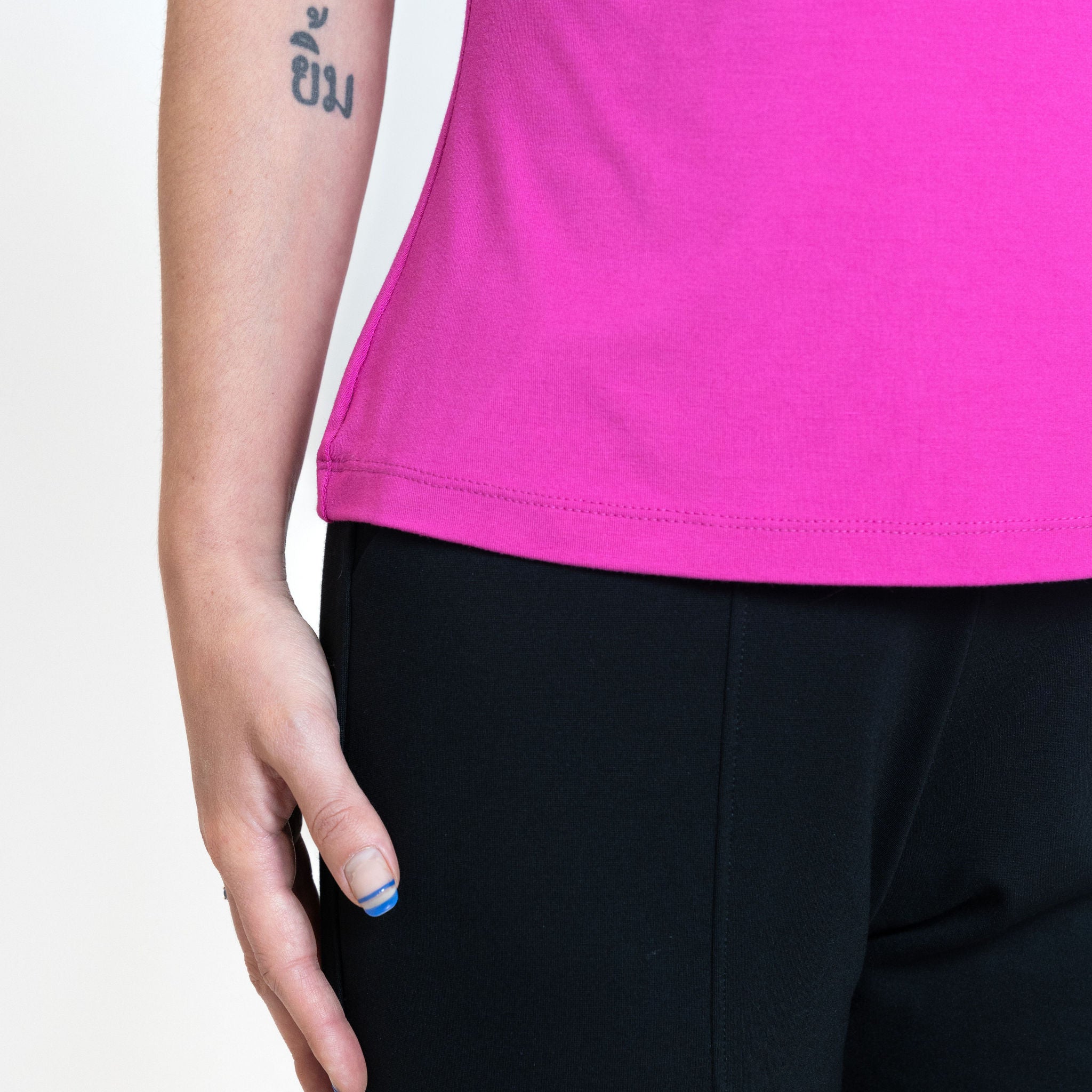 Woman wearing loose bright pink crew neck t-shirt with black tailored ankle length pants