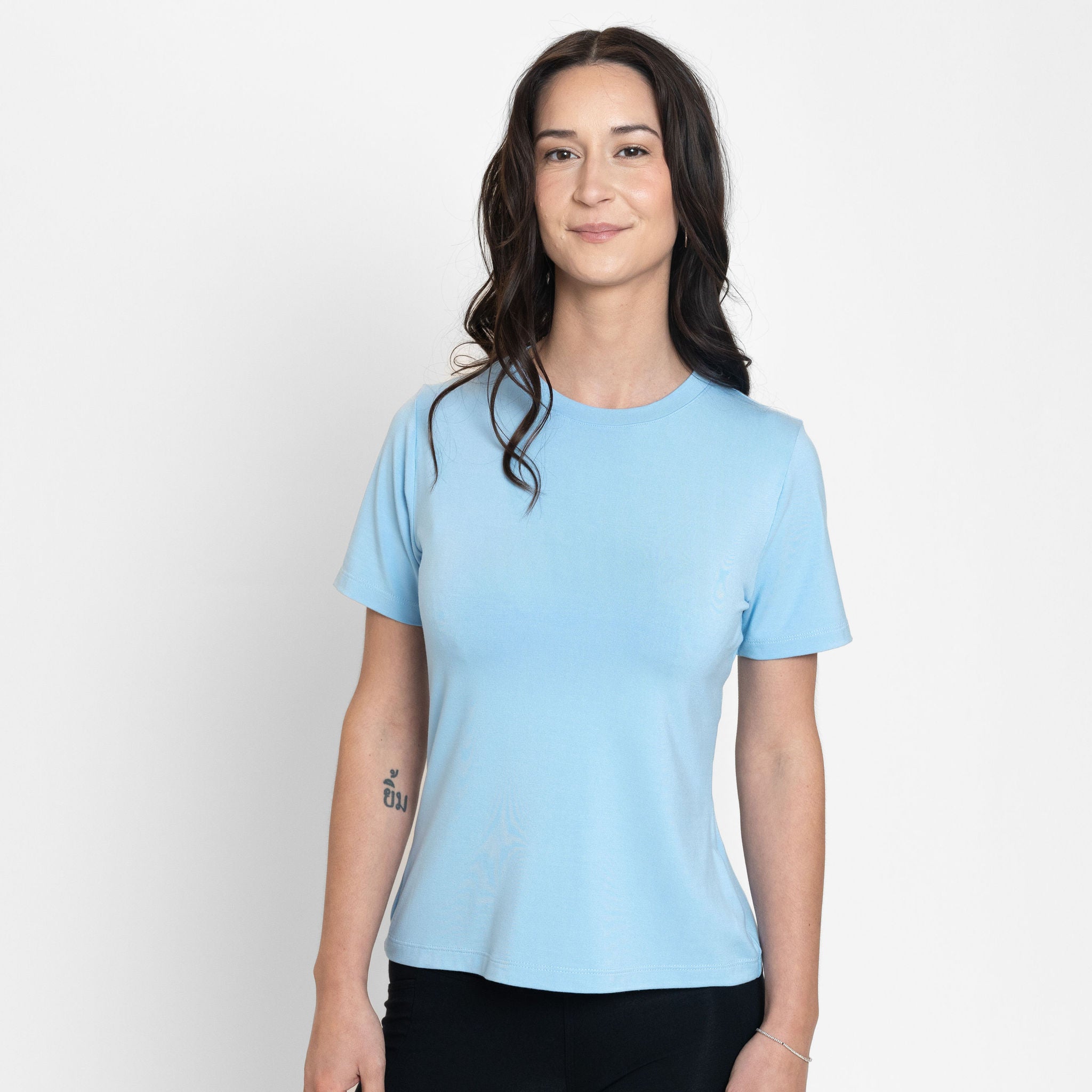 Woman wearing loose light blue crew neck t-shirt with black fitted leggings