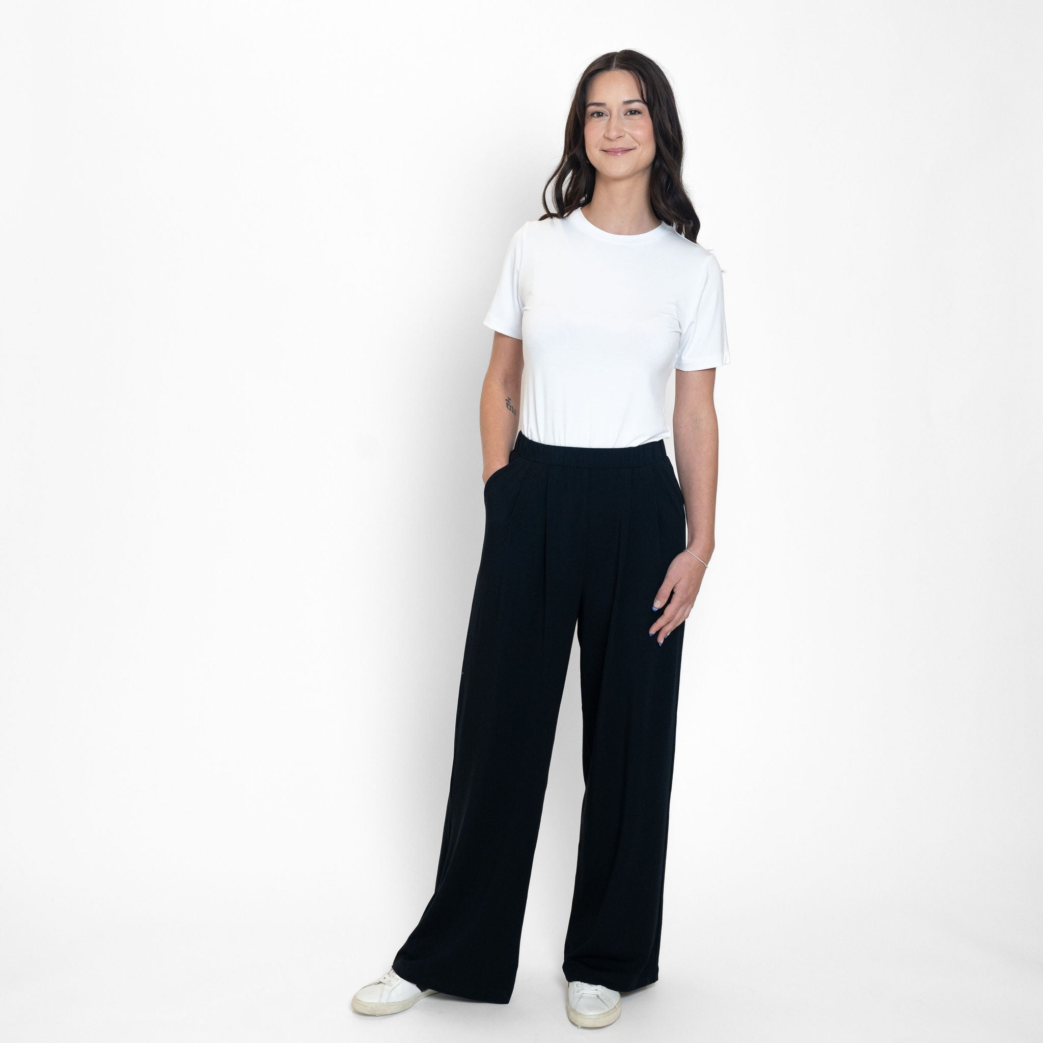 Woman wearing loose white crew neck t-shirt and loose black stretchy wide leg pants