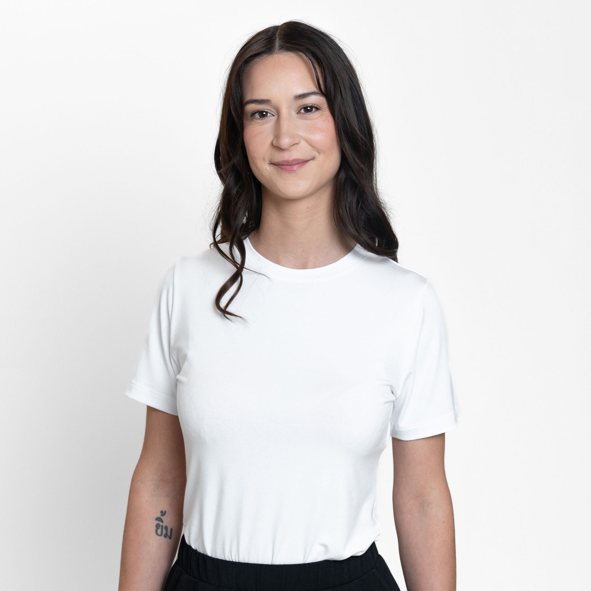 Woman wearing loose white crew neck t-shirt and loose black stretchy wide leg pants