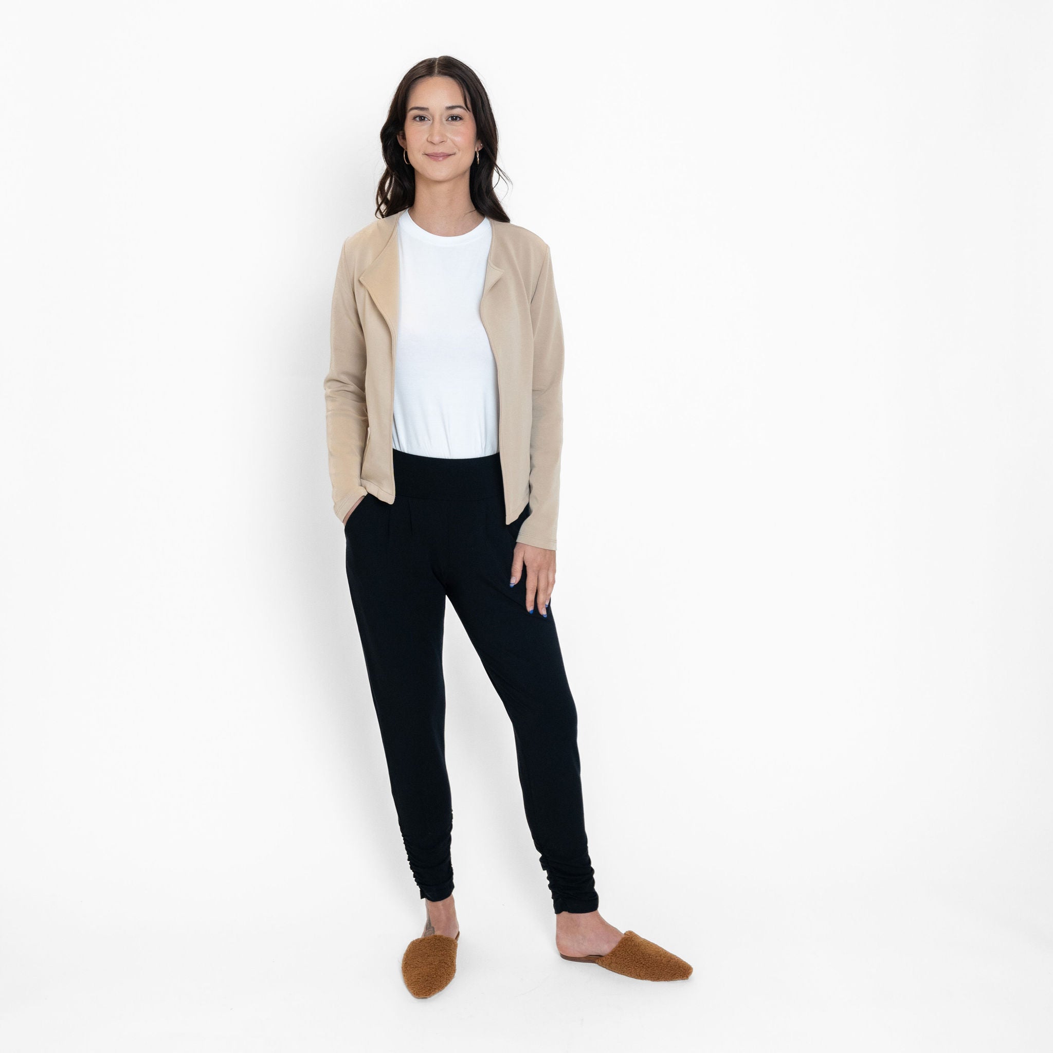 Woman wearing loose white crew neck t-shirt and beige cardigan with fitted black sweatpants