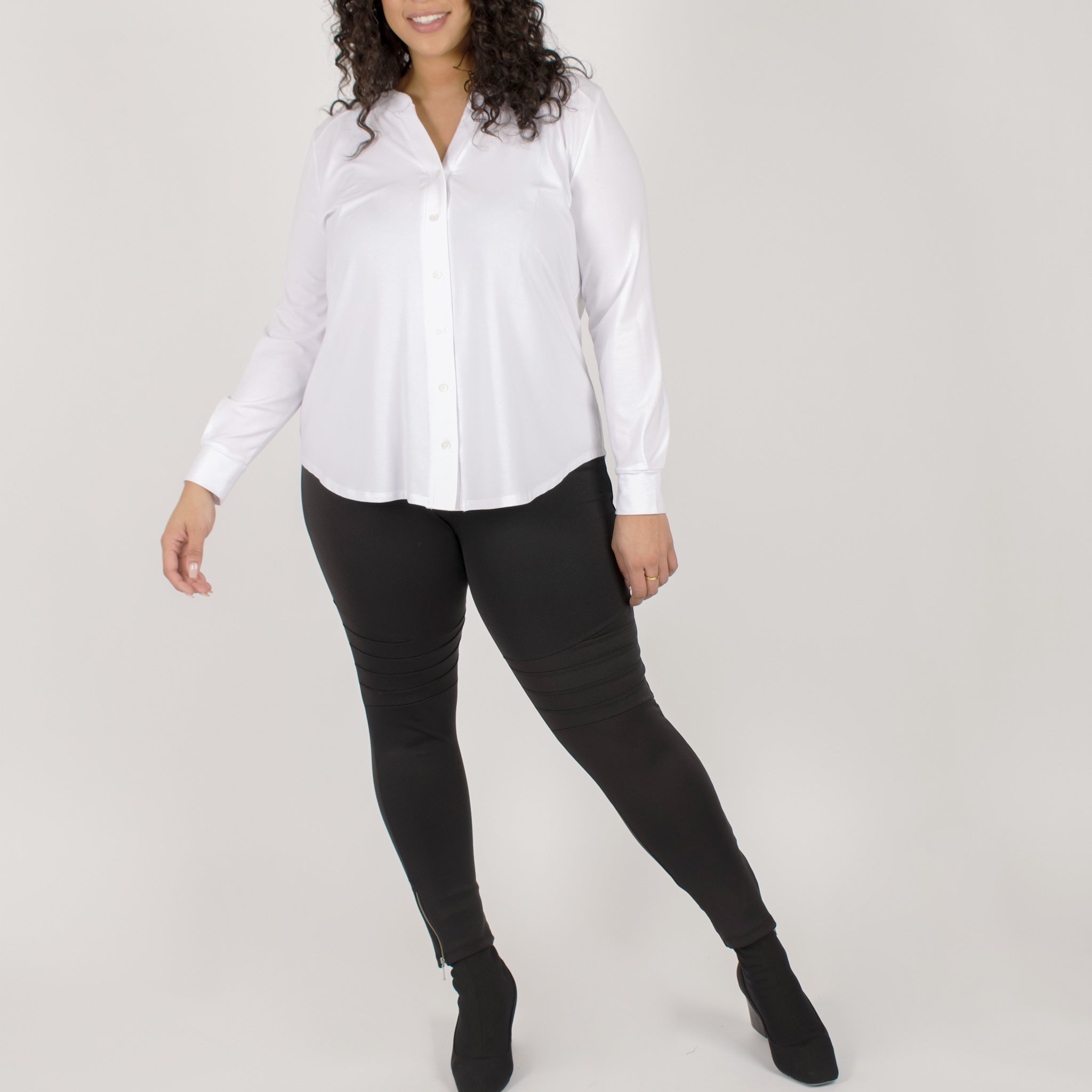 Woman wearing white long sleeve button up shirt with black tapered sweatpants