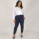 Woman wearing white long sleeve button up shirt with navy tapered sweatpants