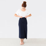 Woman wearing navy blue versatile dress as skirt with white scoop neckline shirt