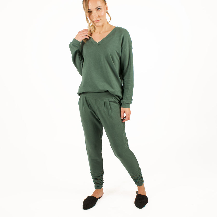Woman wearing green stretchy sweatpants with matching green loose fitted sweatshirt