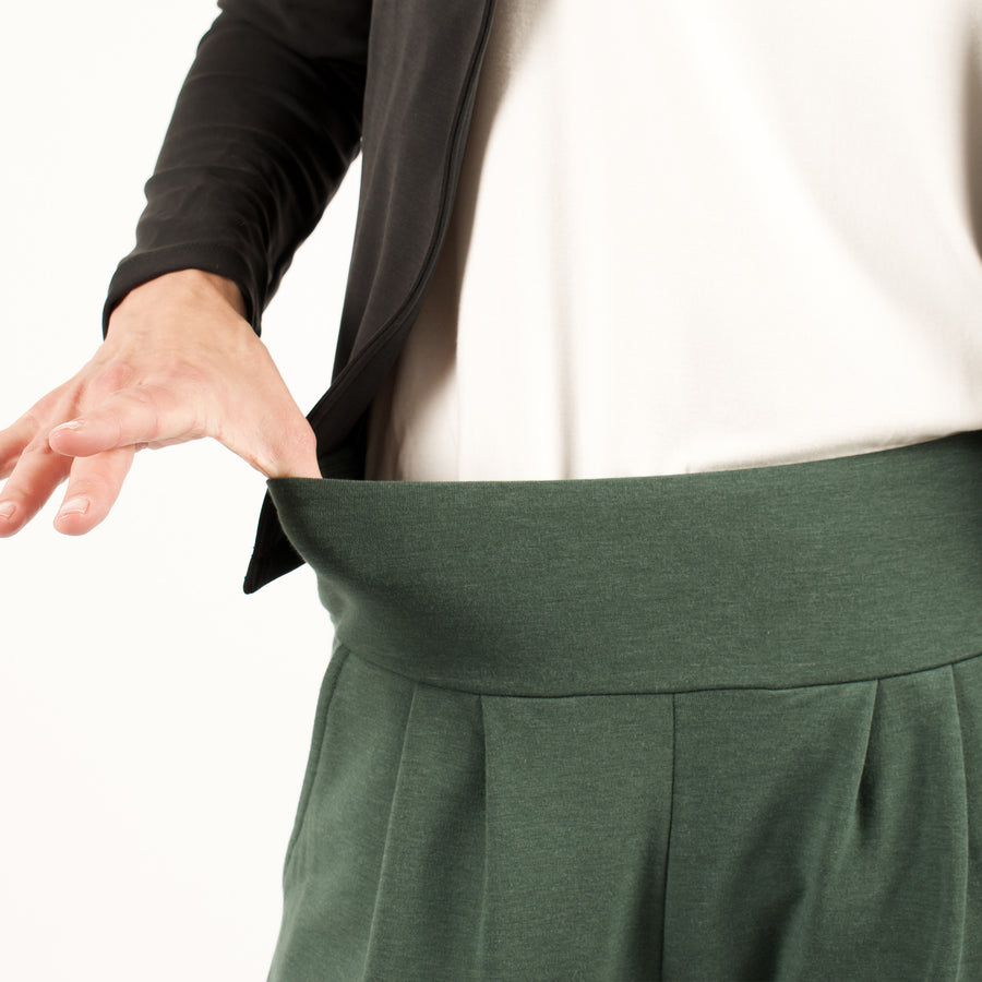 Woman wearing green stretchy sweatpants with white shirt and black cardigan