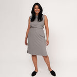 Woman wearing grey body-skimming fit stretchy mid calf length vertical ribbed skirt with tucked in grey sleeveless shirt
