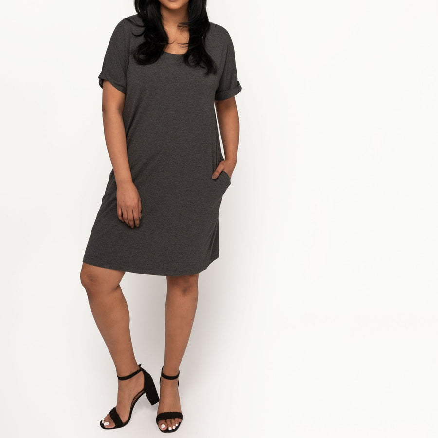 Woman wearing loose dark grey short sleeve knee length dress with pockets
