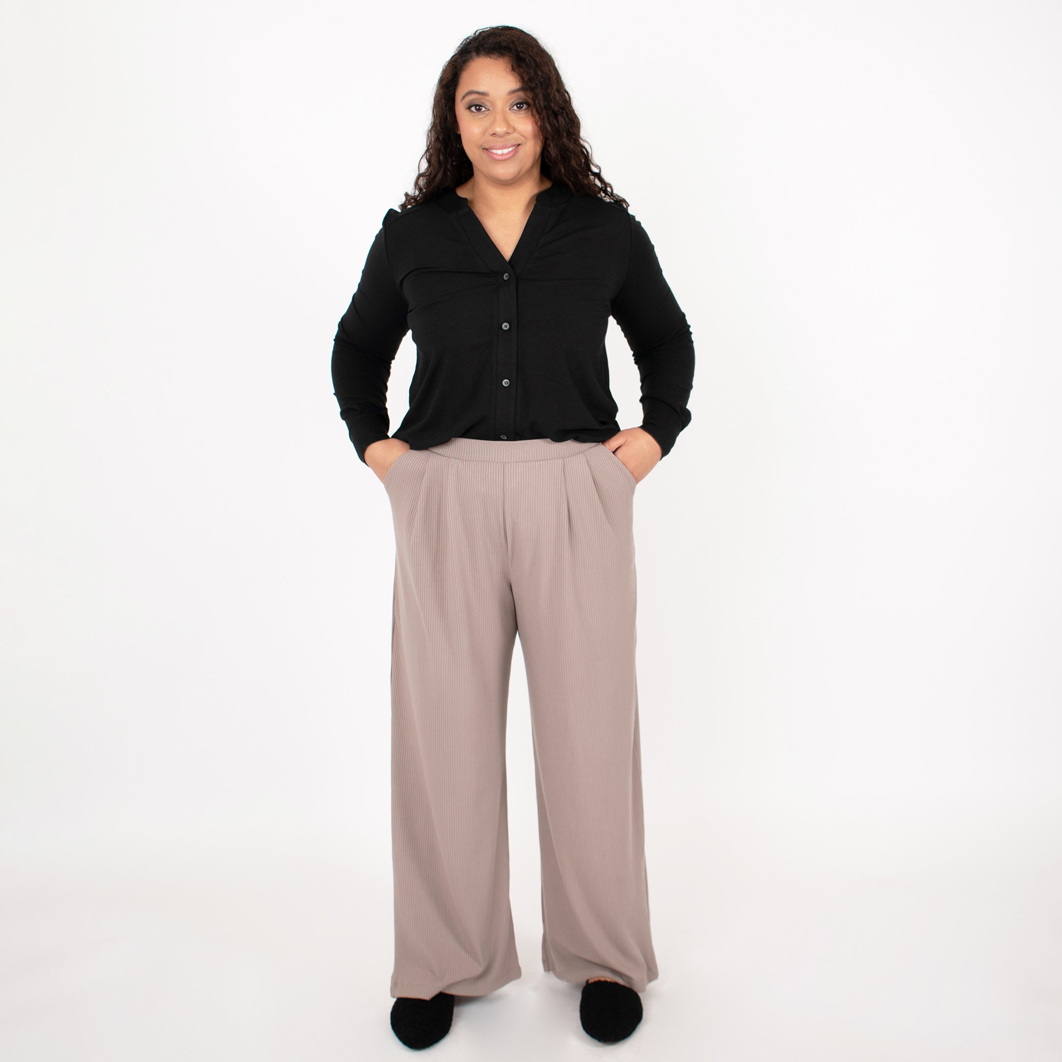 Woman wearing black long sleeve button up shirt with brown wide leg pants