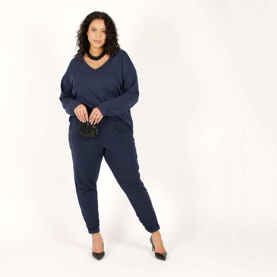 Woman wearing navy stretchy sweatpants with matching blue loose fitted sweatshirt