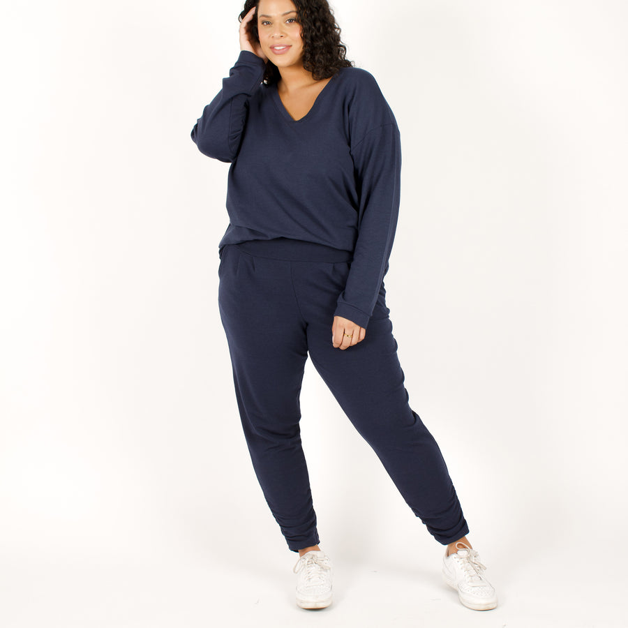 Woman wearing navy stretchy sweatpants with matching blue loose fitted sweatshirt