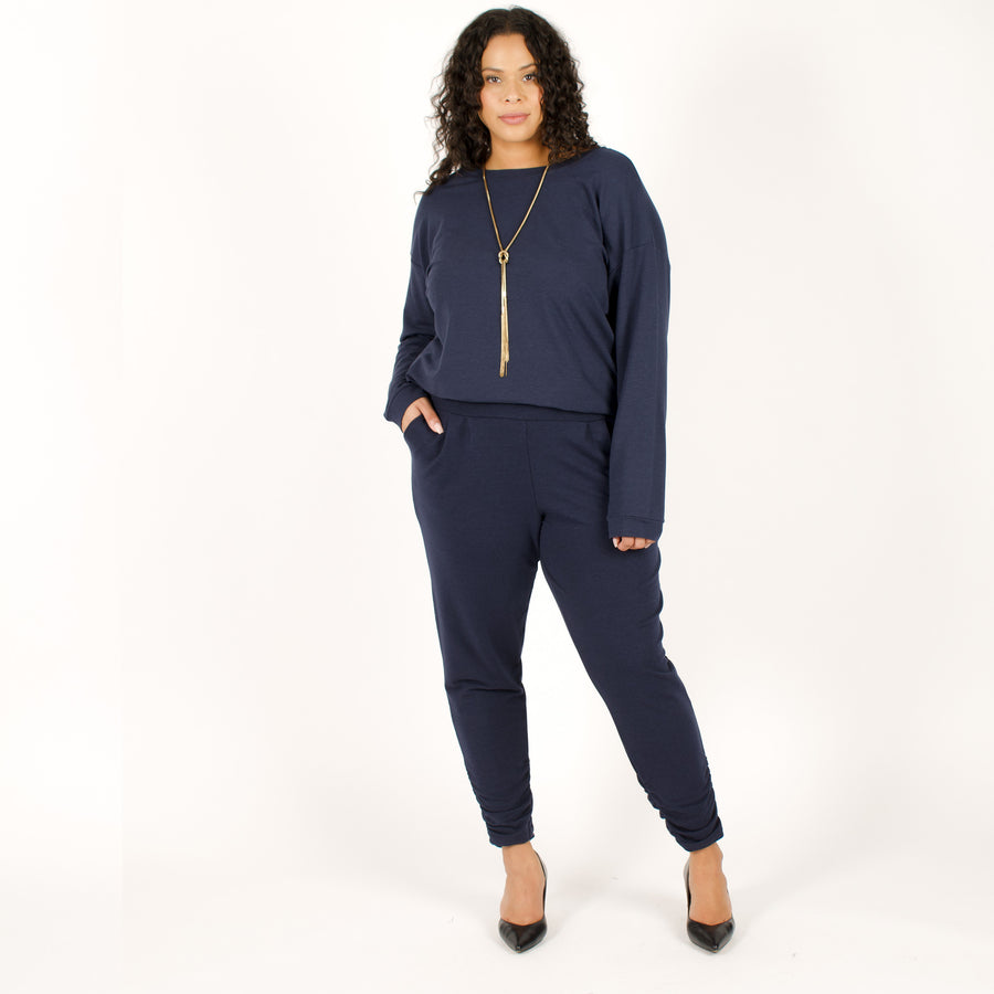 Woman wearing navy stretchy sweatpants with matching blue loose fitted sweatshirt