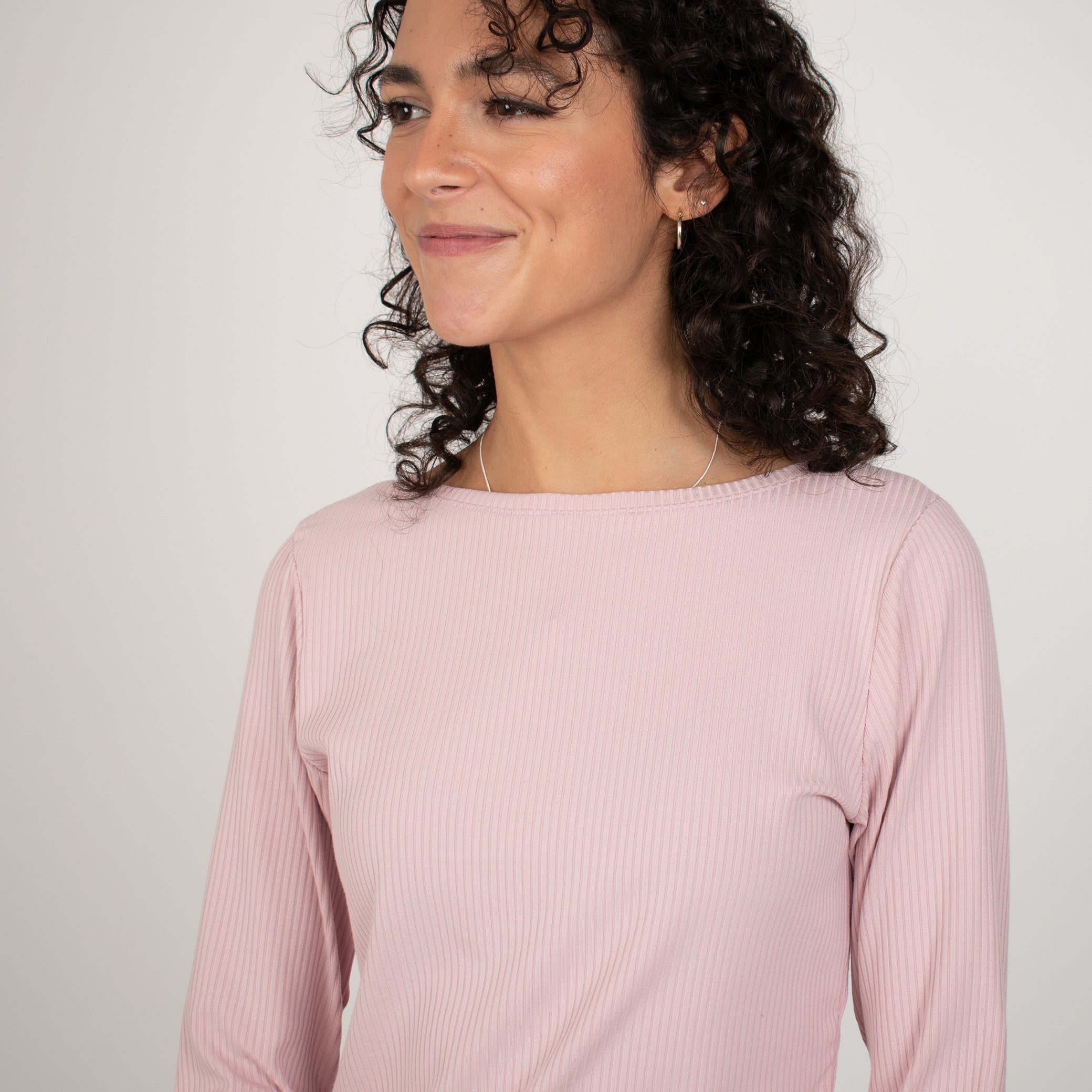 Woman wearing light pink rib knit reversible long sleeve top
