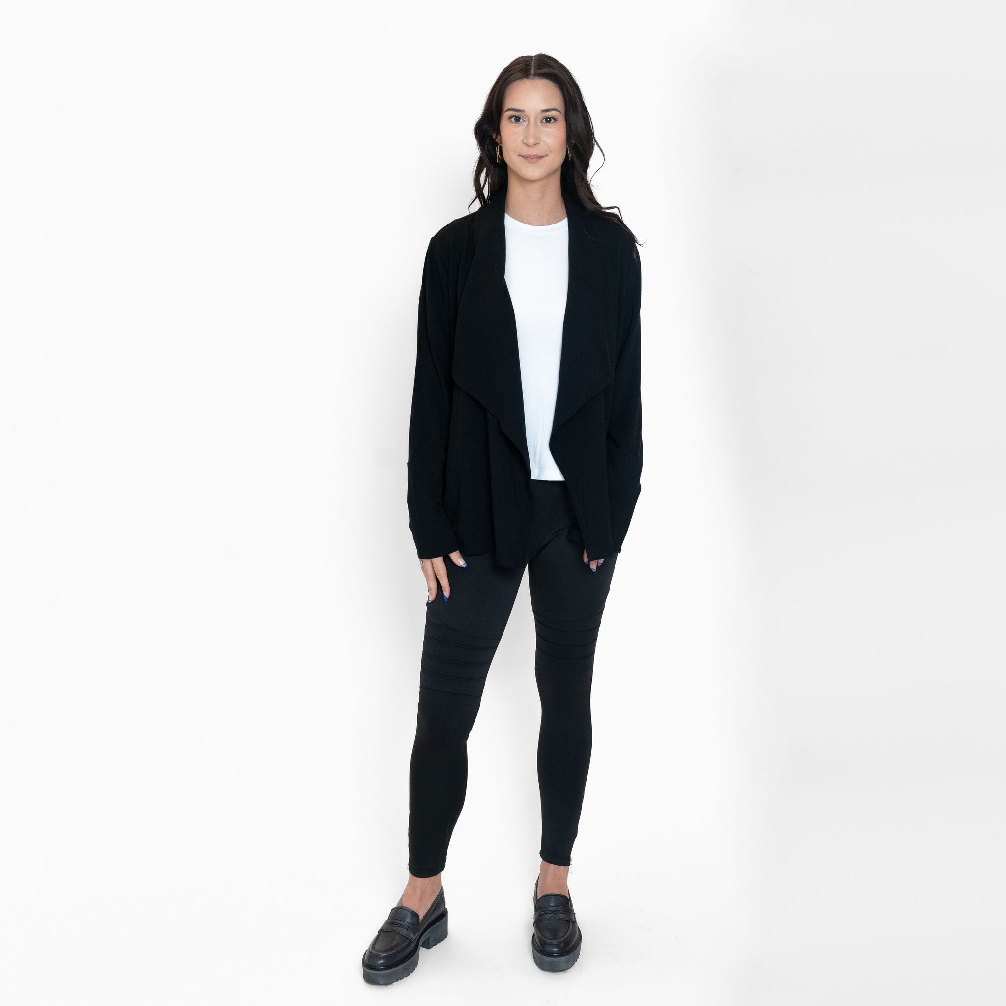 Woman wearing loose white crew neck t-shirt and black cardigan with fitted black sweatpants